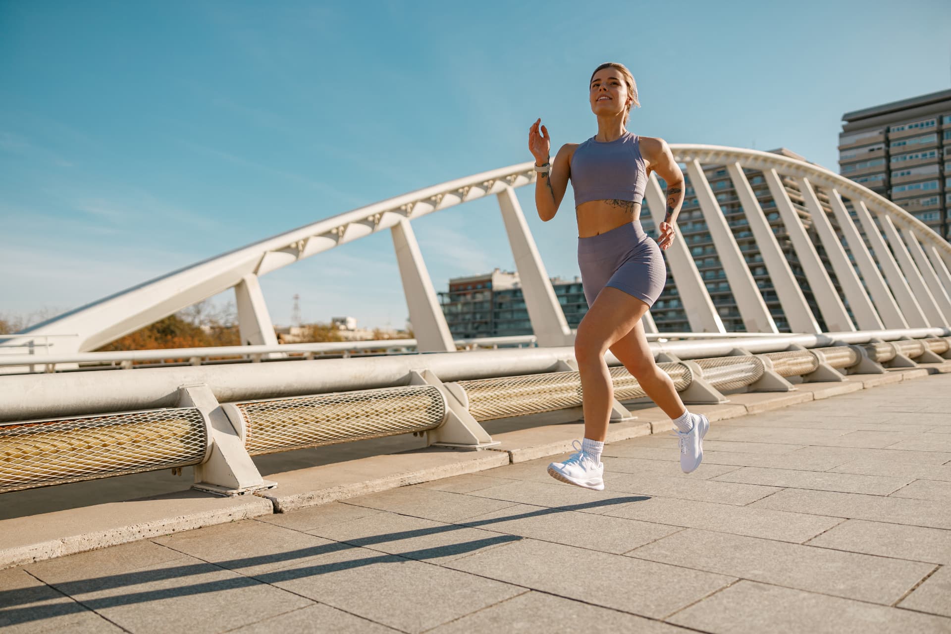 Runner crossing a modern bridge